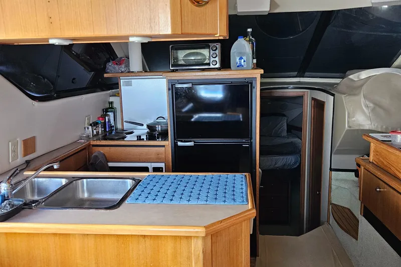 Slide: The Image of 1997 Bayliner 3788 Command Bridge Motoryacht interior with kitchen and sleeping area. - 19