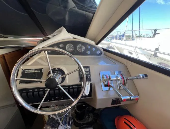 Slide: The Image of 1997 Bayliner 3788 Command Bridge Motoryacht helm with steering wheel and control panel. - 23