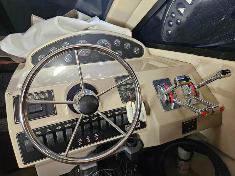 Slide: The Image of 1997 Bayliner 3788 Command Bridge Motoryacht helm with steering wheel and control panel. - 24