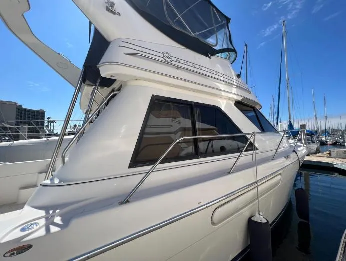 Slide: The Image of 1997 Bayliner 3788 Command Bridge Motoryacht docked at marina under clear blue sky. - 4