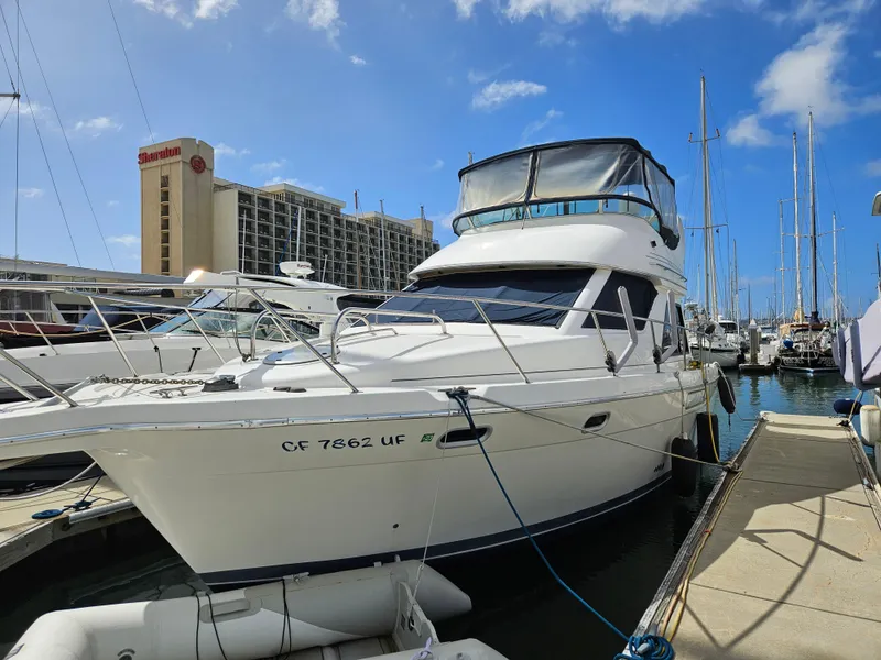 Slide: The Image of 1997 Bayliner 3788 Command Bridge Motoryacht docked at marina under blue sky. - 7