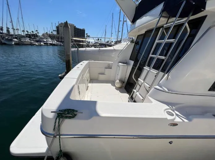 Slide: The Image of 1997 Bayliner 3788 Command Bridge Motoryacht docked at marina, showing spacious deck area. - 8
