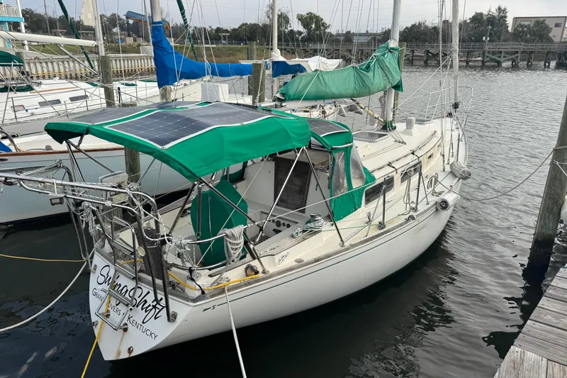 The Image of 1983 Sabre 34 sailboat docked, featuring green canopy and solar panels. - 1