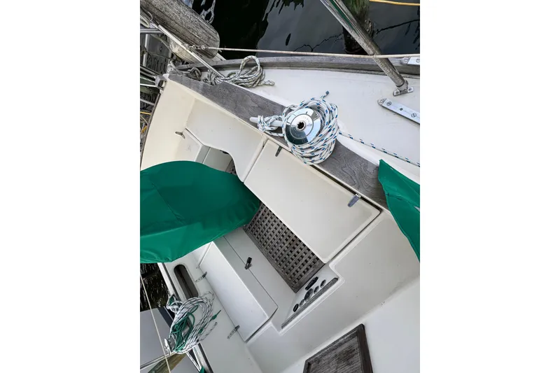 Slide: The Image of 1983 Sabre 34 sailboat deck with green covers and coiled ropes. - 16