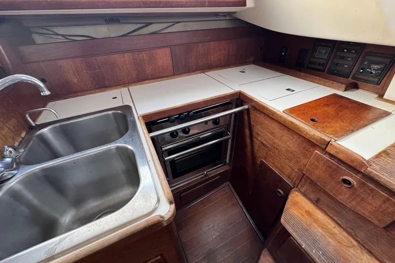 Slide: The Image of 1983 Sabre 34 yacht kitchen with stainless steel sink and wooden cabinetry. - 21