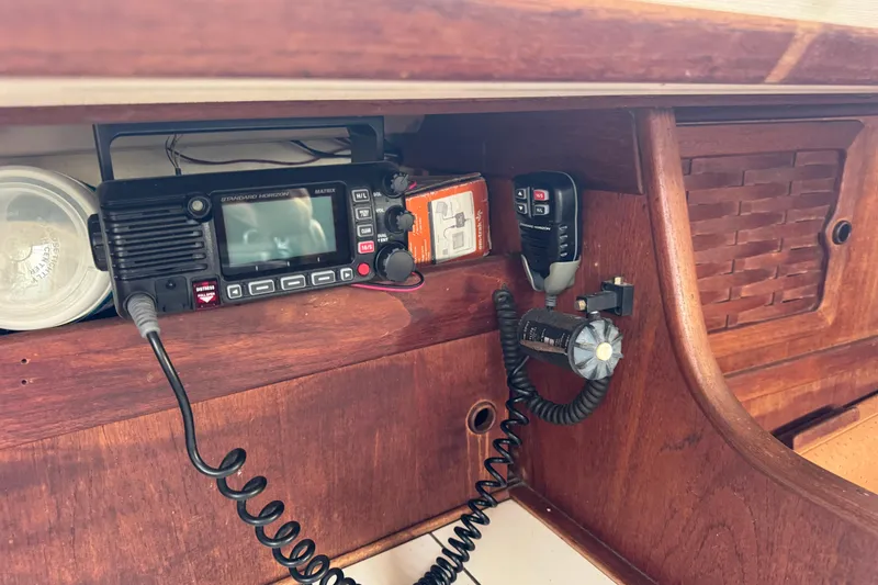 Slide: The Image of VHF radio setup in 1983 Sabre 34 sailboat cabin, featuring wooden interior. - 25