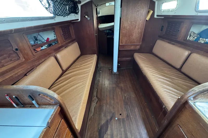 Slide: The Image of Interior of a 1983 Sabre 34 sailboat with wooden furnishings and beige seating. - 26