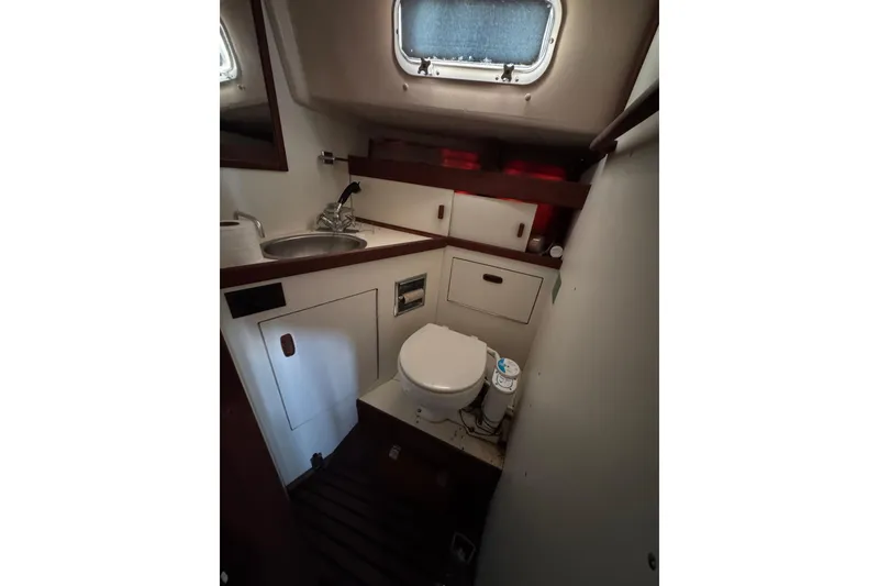 Slide: The Image of 1983 Sabre 34 yacht bathroom with sink, toilet, and storage. - 29