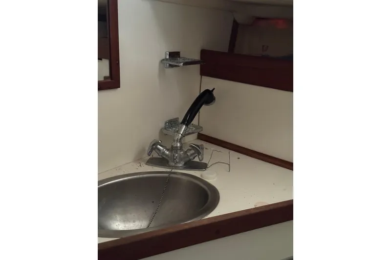 Slide: The Image of 1983 Sabre 34 yacht bathroom sink with chrome faucet and mirror. - 31