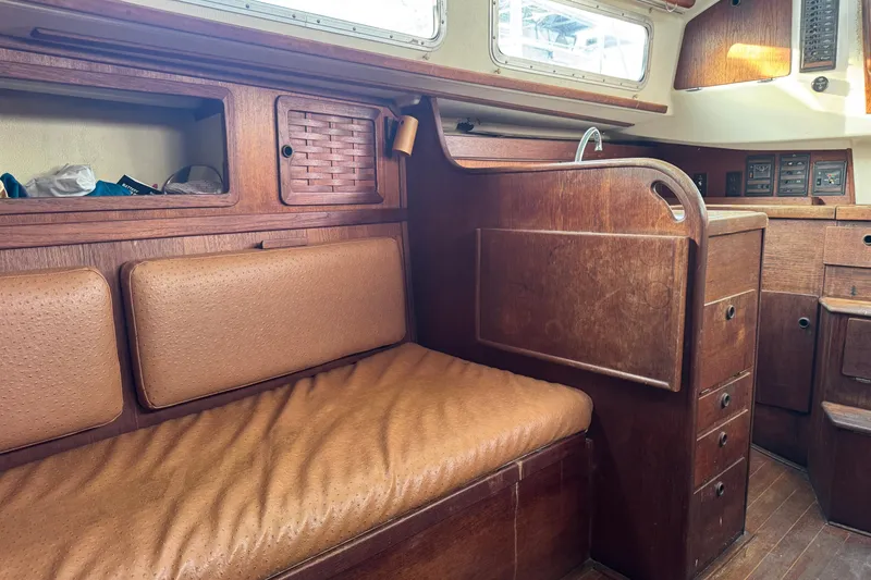 Slide: The Image of Interior of a 1983 Sabre 34 sailboat with wooden cabinetry and cushioned seating. - 35