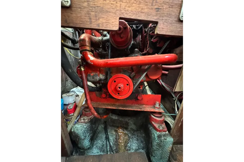 Slide: The Image of Engine compartment of a 1983 Sabre 34 sailboat, featuring red mechanical components. - 37