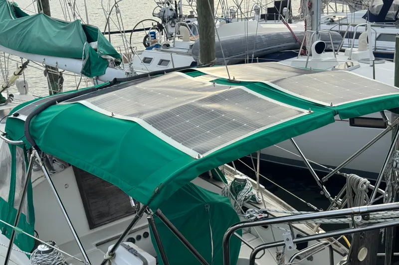 Slide: The Image of 1983 Sabre 34 sailboat with solar panels on green canopy at marina. - 6
