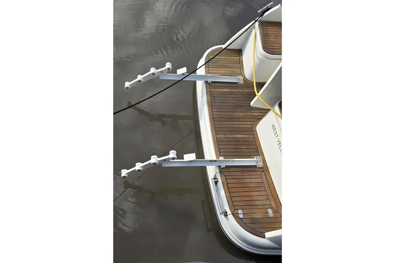 Slide: The Image of 2025 Marex 310 Sun Cruiser with wooden deck and metal fittings, docked on calm water. - 10