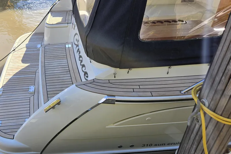 Slide: The Image of 2025 Marex 310 Sun Cruiser docked, featuring sleek design and wooden deck details. - 16