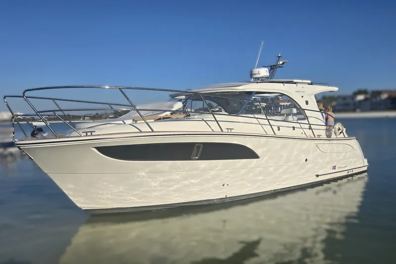Slide: The Image of 2025 Marex 310 Sun Cruiser yacht on calm water under clear blue sky. - 2