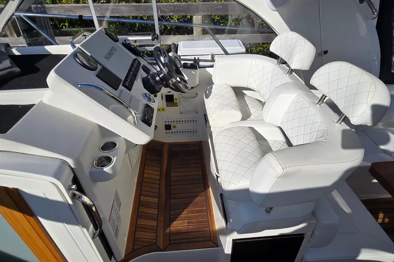 Slide: The Image of Luxurious cockpit of 2025 Marex 310 Sun Cruiser with white leather seating and modern controls. - 21