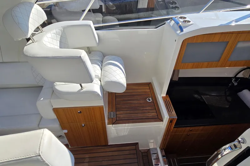 Slide: The Image of Luxurious interior of 2025 Marex 310 Sun Cruiser with white seating and wooden accents. - 24