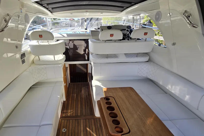 Slide: The Image of 2025 Marex 310 Sun Cruiser interior with white seating and wooden table. - 31