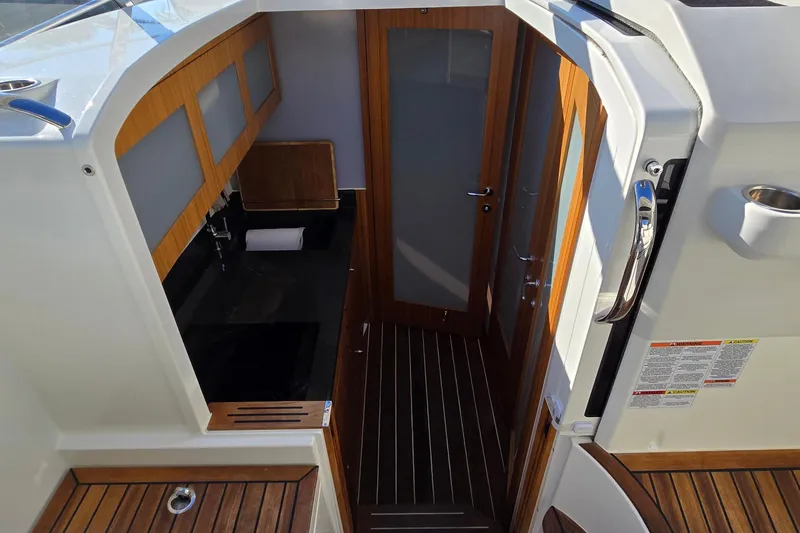 Slide: The Image of 2025 Marex 310 Sun Cruiser interior with wood accents and modern design. - 35