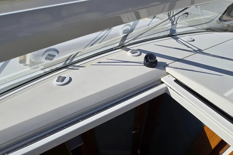 Slide: The Image of 2025 Marex 310 Sun Cruiser deck detail with compass and sleek design elements. - 41