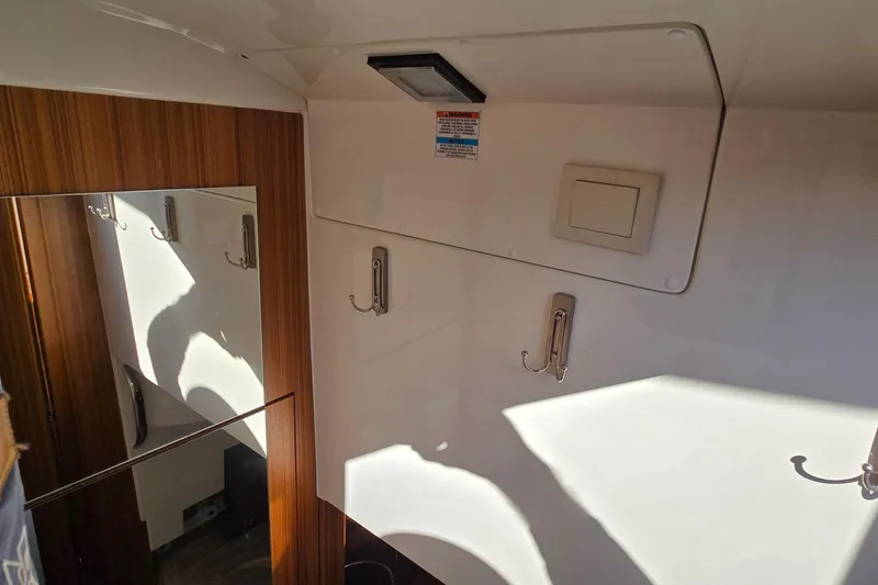 Slide: The Image of Interior of 2025 Marex 310 Sun Cruiser with wooden paneling and coat hooks. - 49