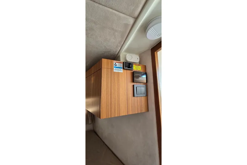 Slide: The Image of Interior control panel of 2025 Marex 310 Sun Cruiser with wood finish. - 54