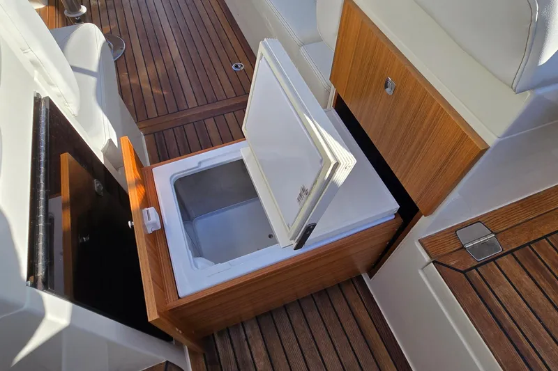 Slide: The Image of 2025 Marex 310 Sun Cruiser interior with open storage compartment and wooden flooring. - 57
