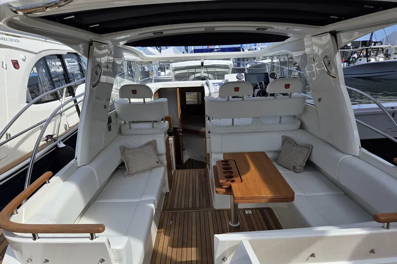 Slide: The Image of 2025 Marex 310 Sun Cruiser interior with elegant seating and wooden table. - 8