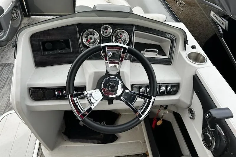 Slide: The Image of 2022 Tahoe Pontoon LTZ Quad Lounger dashboard with steering wheel and control panel. - 12