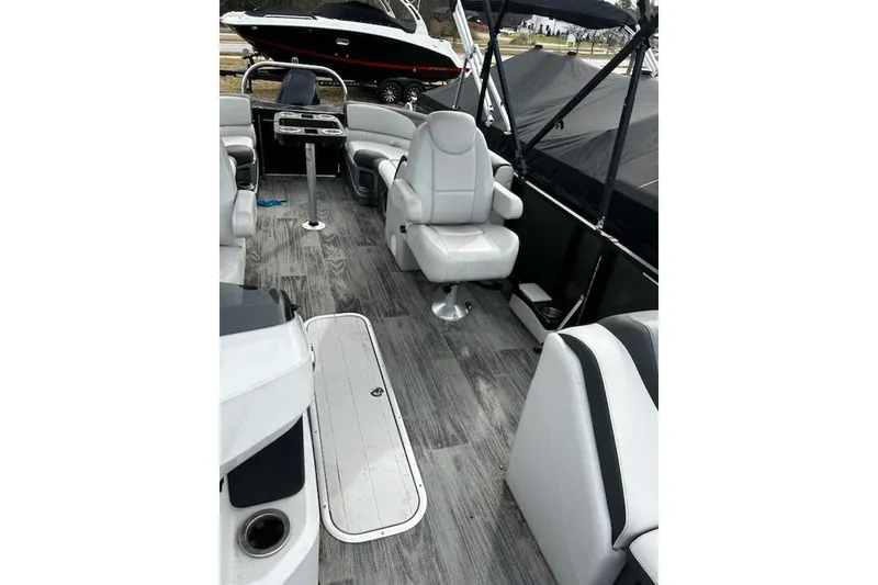 Slide: The Image of 2022 Tahoe Pontoon LTZ Quad Lounger interior with gray seating and wood-style flooring. - 8