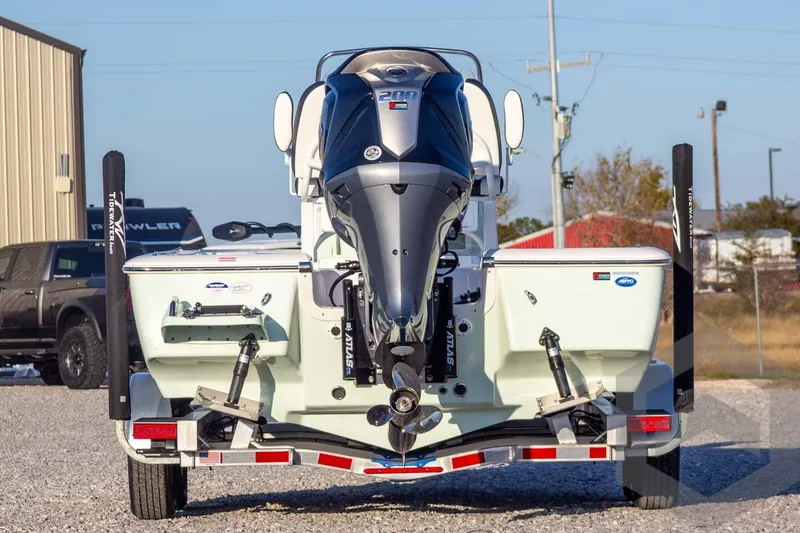 Slide: The Image of 2026 Tidewater 2110 Bay Max boat with powerful outboard motor, parked on gravel. - 13