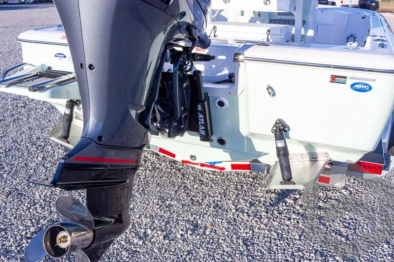 Slide: The Image of 2026 Tidewater 2110 Bay Max boat with outboard motor and trim tabs on gravel surface. - 33
