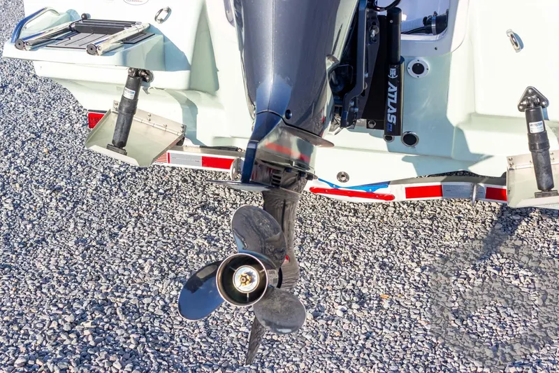 Slide: The Image of 2026 Tidewater 2110 Bay Max boat with outboard motor and propeller on gravel. - 35