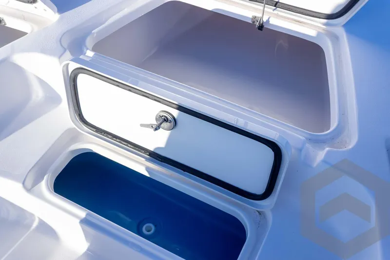 Slide: The Image of 2026 Tidewater 2110 Bay Max boat storage compartments with secure latch and blue interior. - 40
