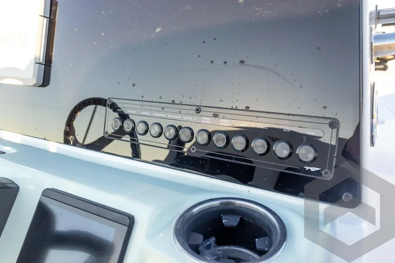 Slide: The Image of Control panel of 2026 Tidewater 2110 Bay Max boat with switches and cup holder. - 54
