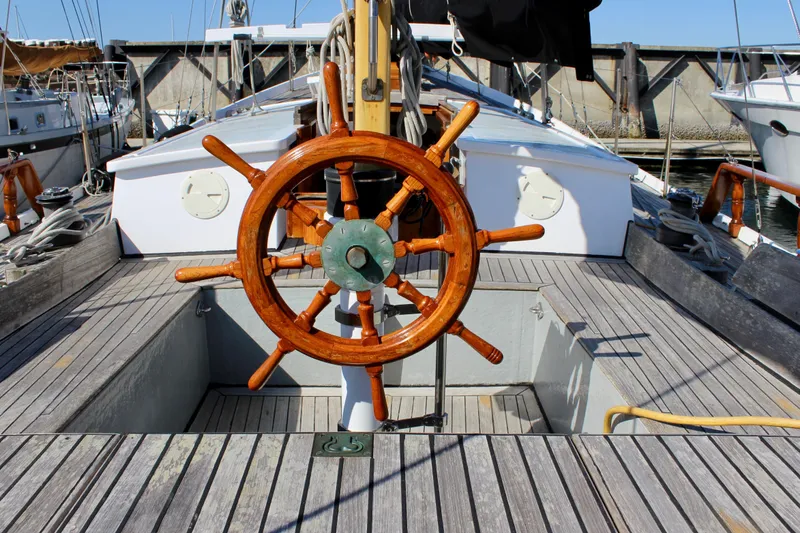 Slide: The Image of Wooden steering wheel on 1975 William Garden Porpoise sailboat deck, docked in marina. - 10