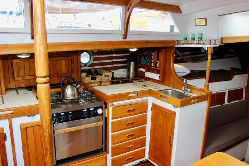 Slide: The Image of Cozy 1975 William Garden Porpoise yacht interior with wooden kitchen and stainless steel appliances. - 17