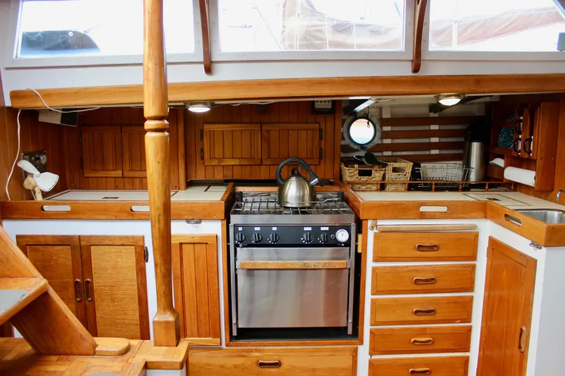 Slide: The Image of 1975 William Garden Porpoise yacht kitchen with wooden cabinetry and stainless steel stove. - 18