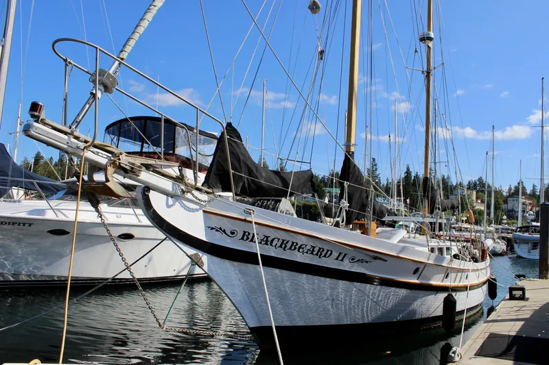 Slide: The Image of 1975 William Garden Porpoise sailboat, "Blackbeard II," docked in a marina under clear skies. - 2