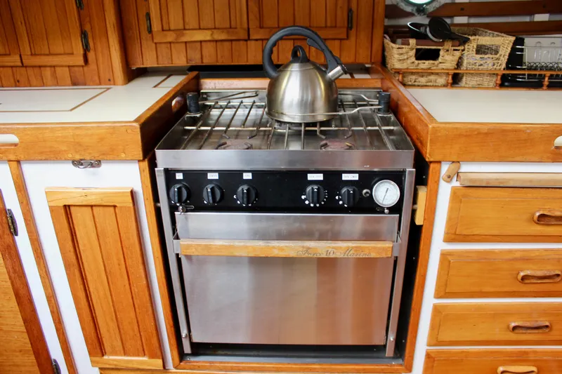 Slide: The Image of 1975 William Garden Porpoise yacht kitchen with stove and kettle. - 20