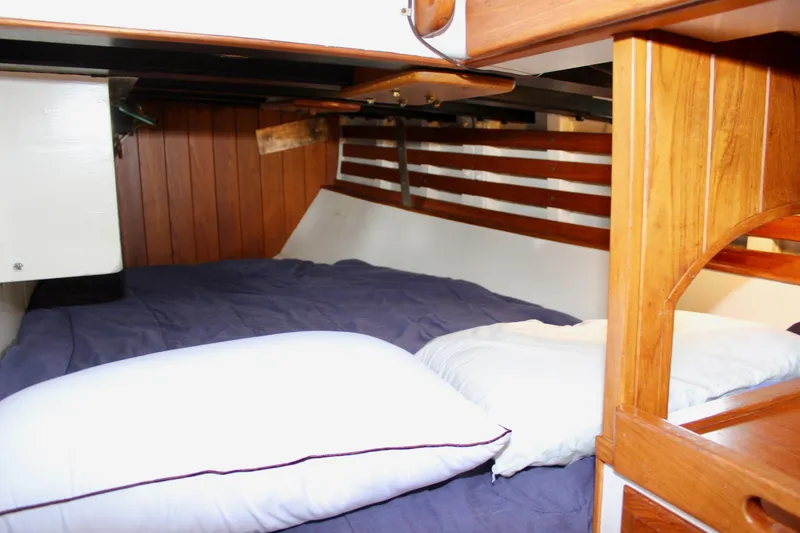 Slide: The Image of Cozy cabin interior of 1975 William Garden Porpoise sailboat with wooden paneling and bedding. - 28