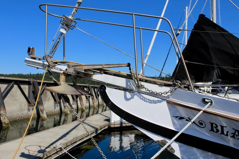 Slide: The Image of 1975 William Garden Porpoise sailboat docked, featuring anchor and rigging against clear blue sky. - 3