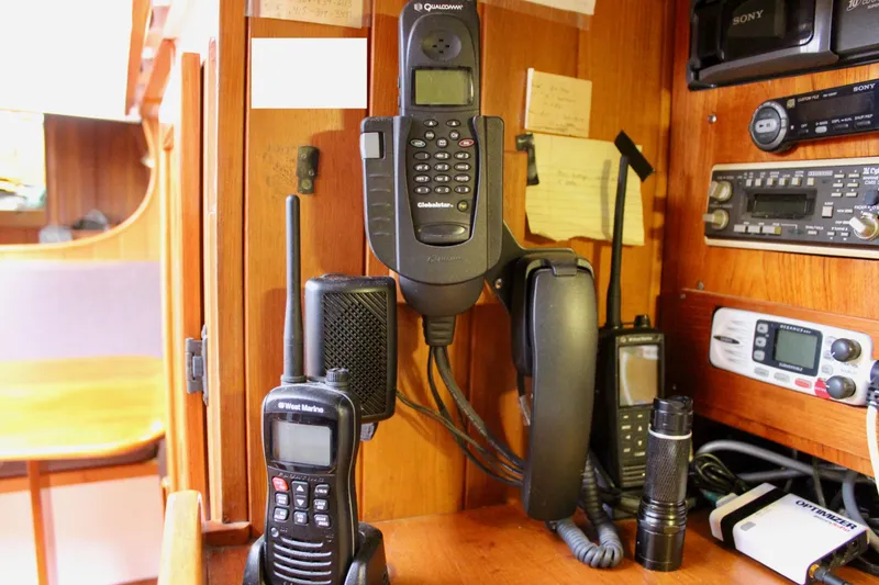 Slide: The Image of Communication equipment inside a 1975 William Garden Porpoise boat, featuring radios and a satellite phone. - 32