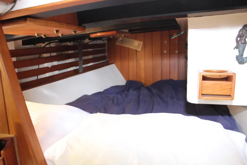 Slide: The Image of Cozy cabin interior of 1975 William Garden Porpoise sailboat with wooden accents and bedding. - 33