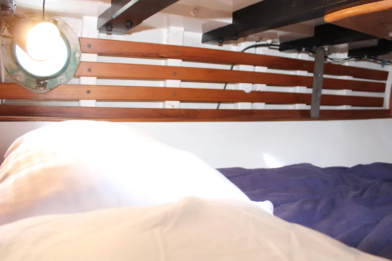 Slide: The Image of Cozy cabin interior of 1975 William Garden Porpoise sailboat with porthole and wooden paneling. - 34