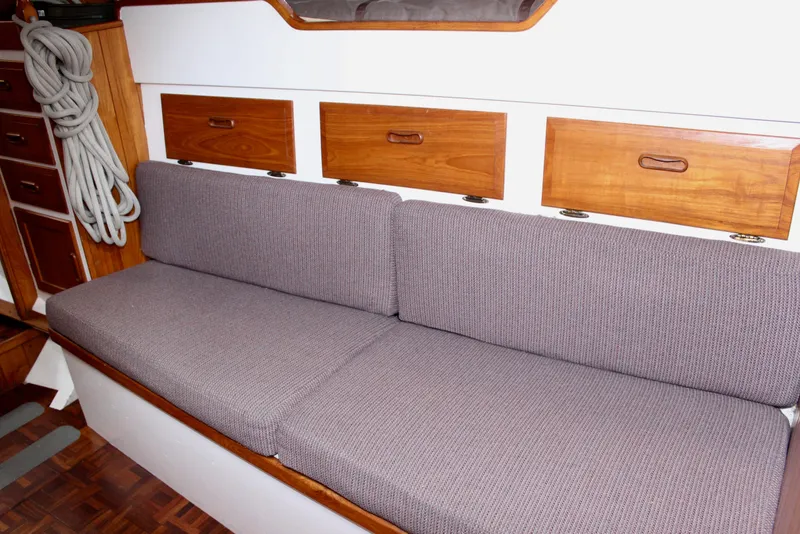 Slide: The Image of Interior of 1975 William Garden Porpoise boat with cushioned seating and wooden storage. - 40