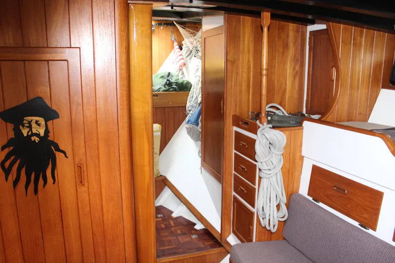 Slide: The Image of Interior of 1975 William Garden Porpoise sailboat with wooden cabinetry and pirate-themed decor. - 46