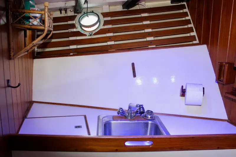 Slide: The Image of 1975 William Garden Porpoise boat interior with sink, wooden accents, and nautical decor. - 47