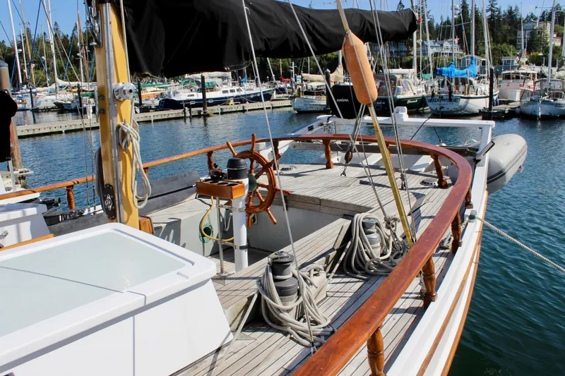 Slide: The Image of 1975 William Garden Porpoise sailboat docked in a marina, featuring wooden deck and steering wheel. - 5