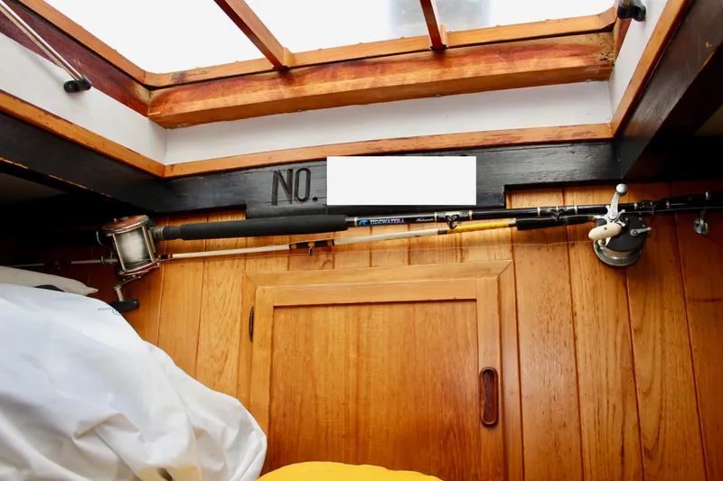 Slide: The Image of Interior of 1975 William Garden Porpoise boat with fishing rod and wooden paneling. - 51